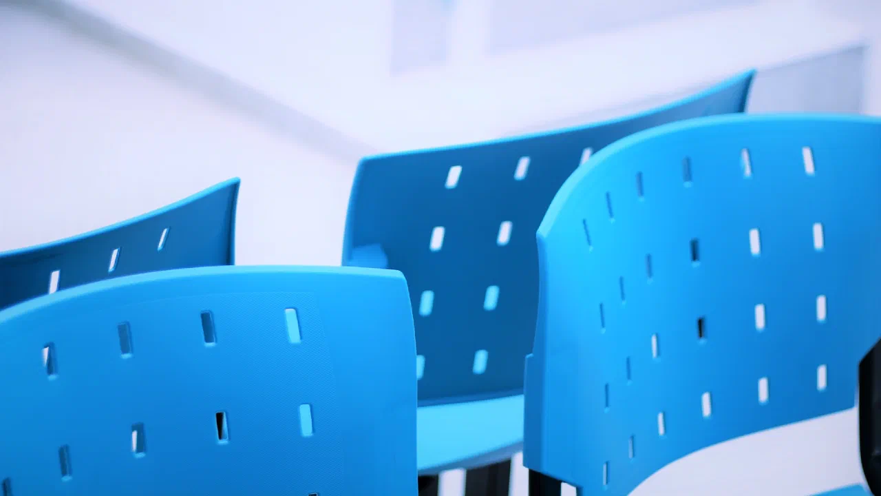 A row of empty blue waiting-room chairs